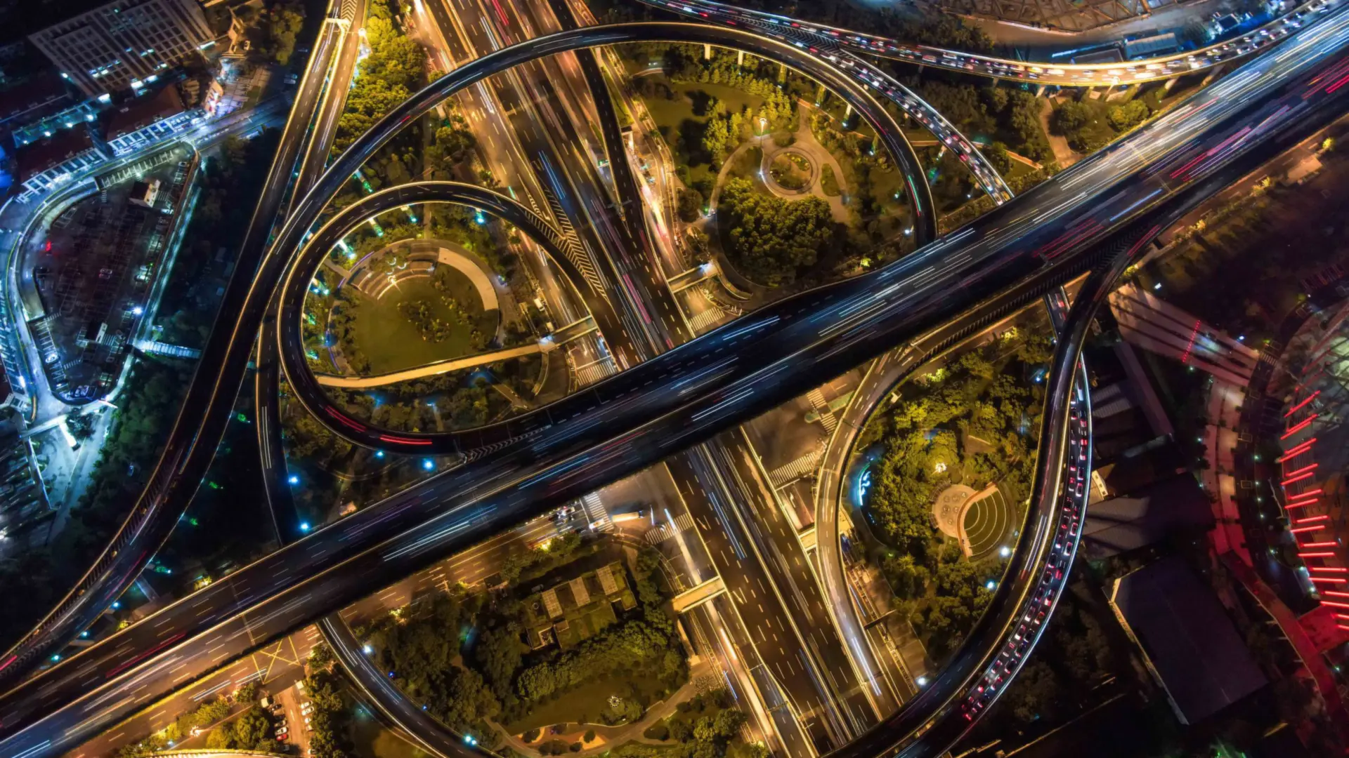 Aerial view of city highways and a roundabout lit up at night