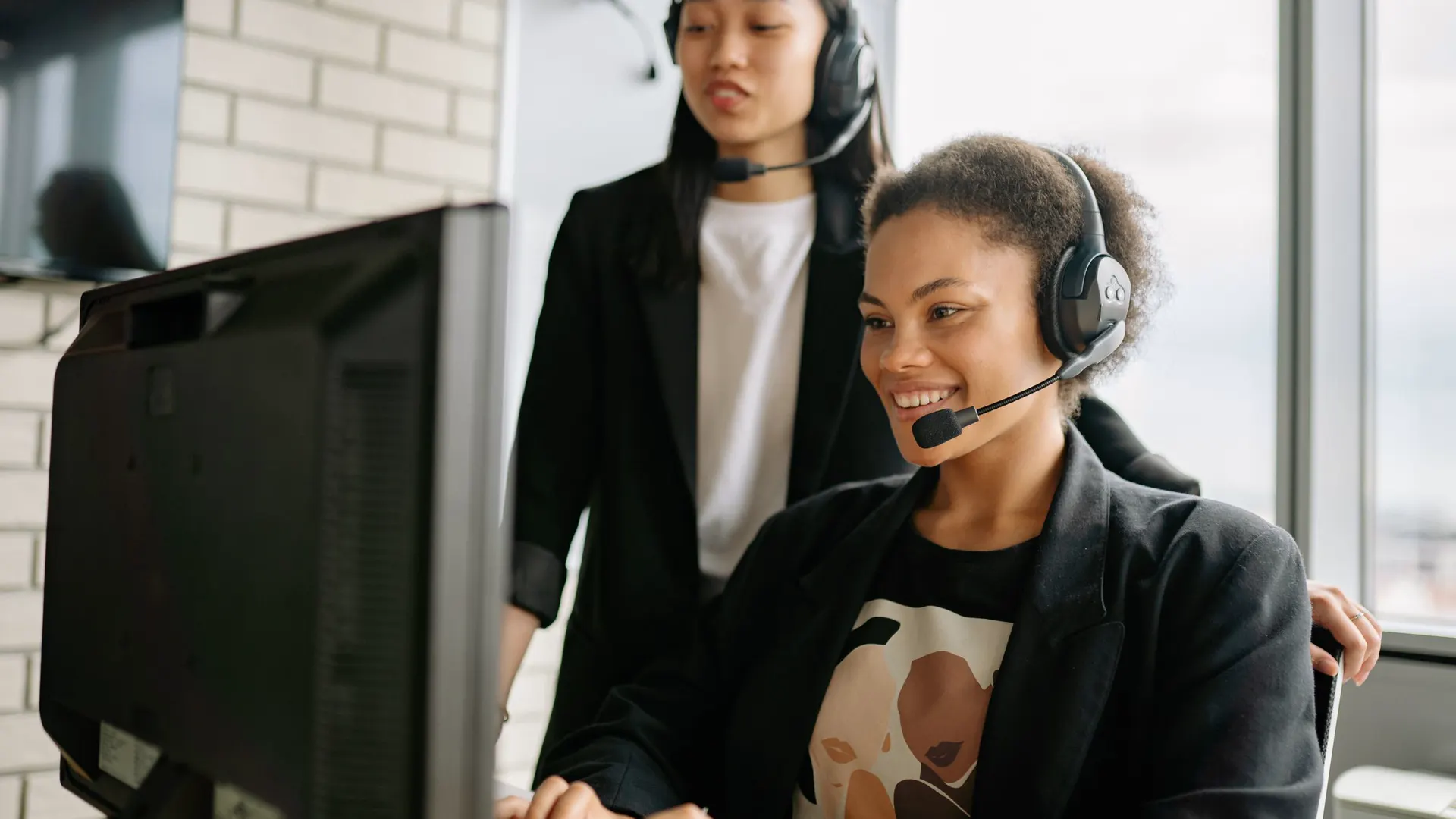 Support team members with headsets working at a computer